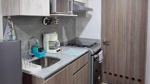 A compact kitchen with a sink, stove, and cabinets. - 103 Insurgentes Nayeli (Mexico City)