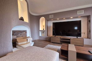 A modern living room with a large flat-screen TV, built-in wooden entertainment unit, and a cozy seating area with a fireplace. - Fabian (Rio de Janeiro) (Mexico City)