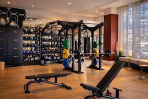 A gym with weightlifting equipment, kettlebells, and dumbbells. - N Miami Ave - Suites (Miami)