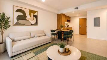 Una sala de estar moderna con un sofá, una mesa de centro y un comedor con sillas y una mesa.