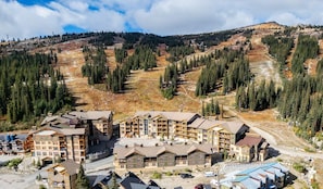 A lodge with multiple buildings, a ski slope in the background, and a mountainous landscape. - Spacious family ski in/ski out retreat with private hot tub (Beaverdell)