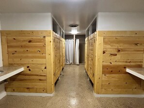 A corridor with wooden bunk beds on either side, leading to a bathroom with a shower curtain. - Unique Glamping tent with 2 twin beds in Sturgis South Dakota (Sturgis)