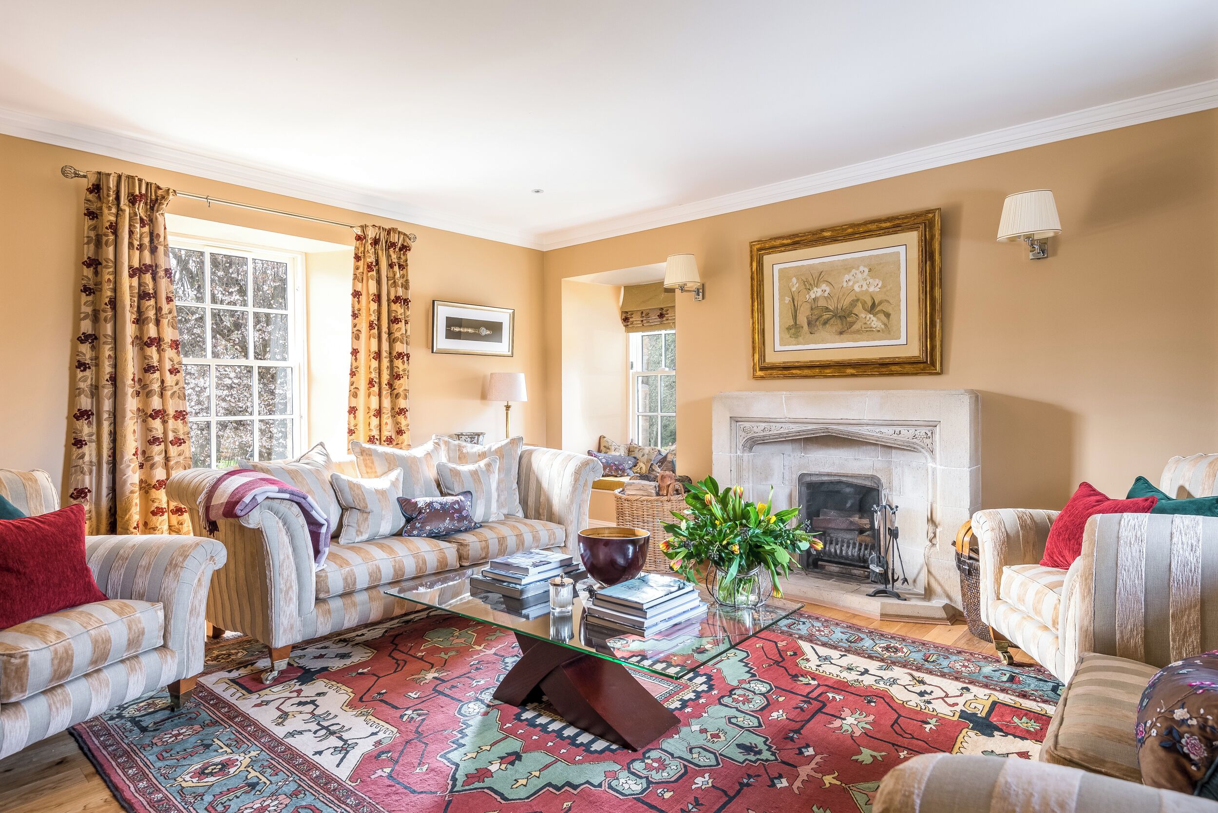 A living room with a fireplace, a sofa, a coffee table, and a patterned rug.