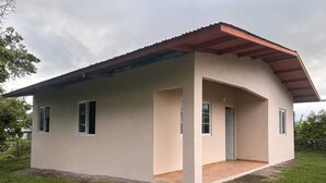 A single-story building with a flat roof, a covered porch, and a small front door.