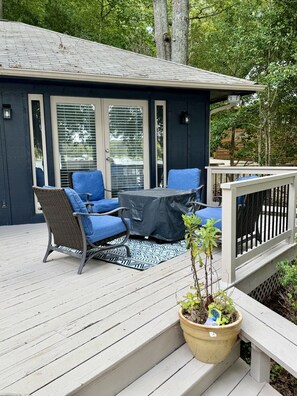 Une terrasse dotée de mobilier d’extérieur, d’une table abritée et d’une plante en pot.
