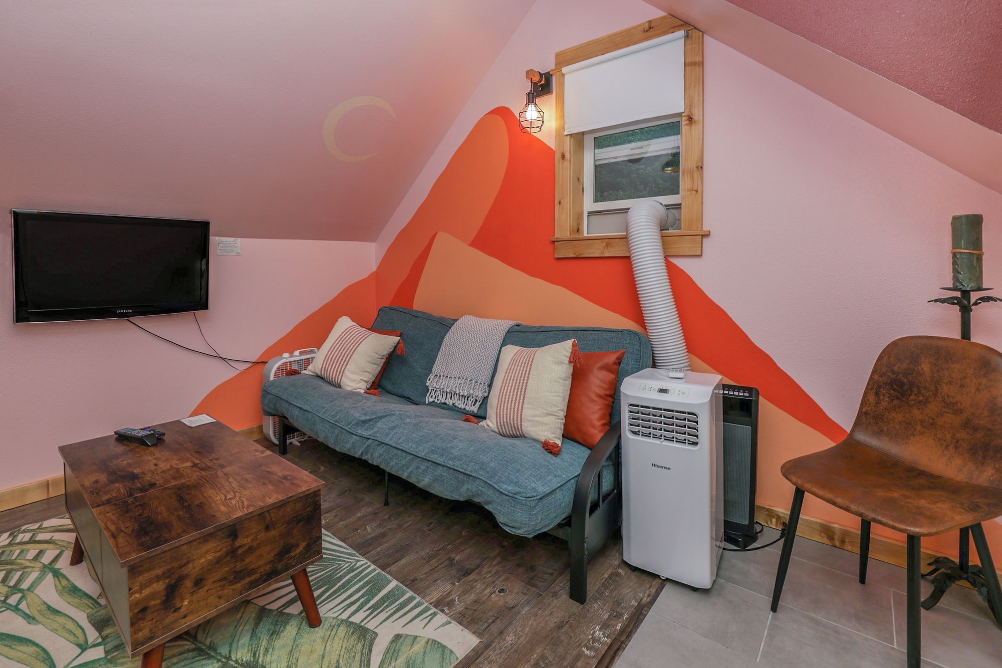 Une pièce confortable avec un canapé, un fauteuil, un téléviseur et un radiateur.