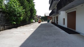A quiet street with a row of buildings, a metal fence, and a clear sky. - Wifi, 200m from ski lifts, 1st floor, balcony, 21m², Les Gets (Les Gets)