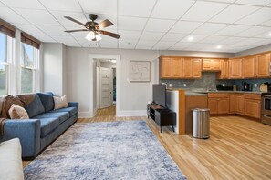 A modern kitchen with wooden cabinets, a stainless steel refrigerator, and a built-in oven.