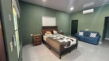 A bedroom with a bed, bedside tables, a blue sofa, and a wardrobe.