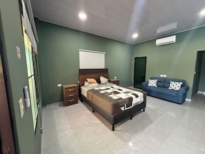 A bedroom with a bed, bedside tables, a blue sofa, and a wardrobe.