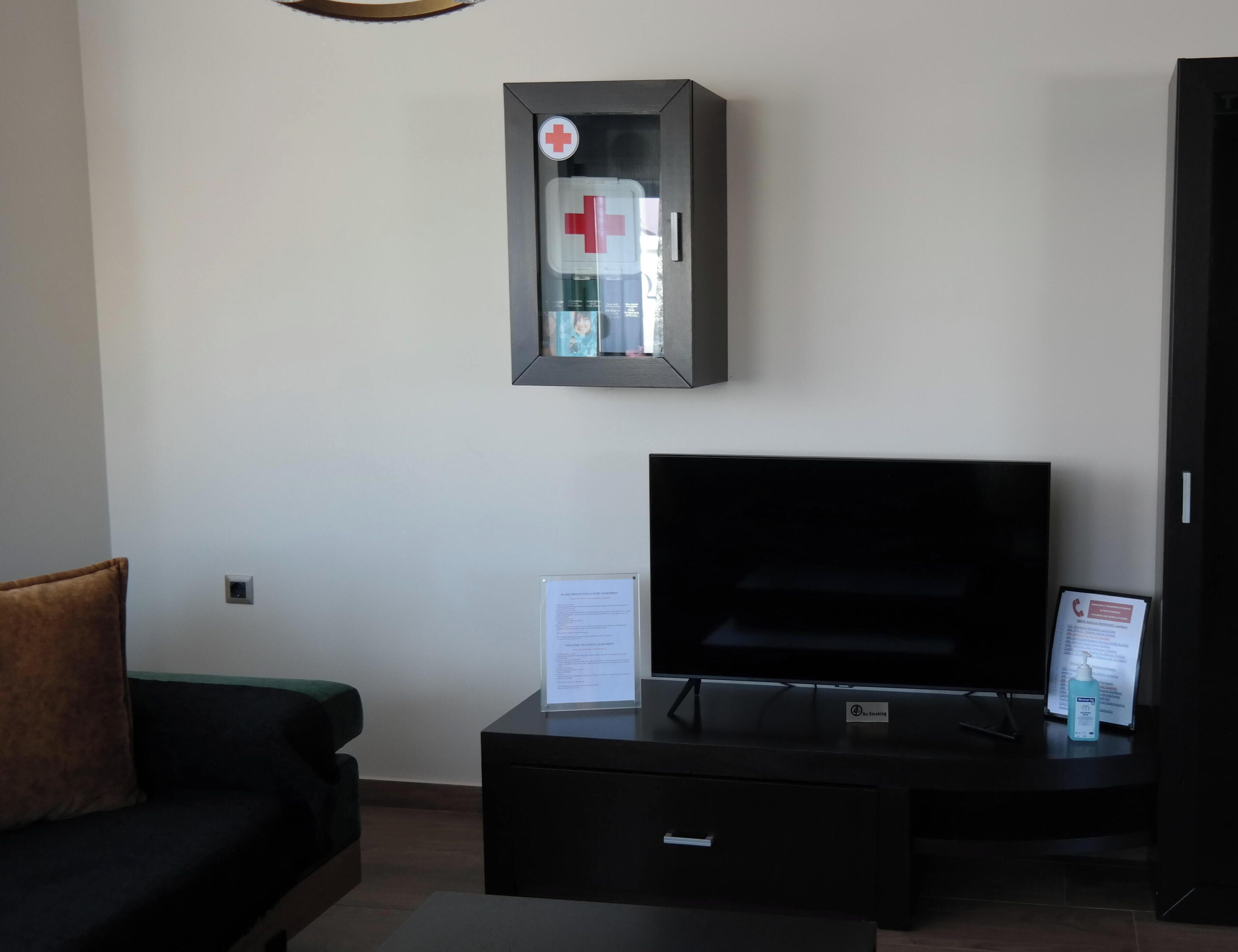 A living room with a flat-screen TV, a sofa, a coffee table, and a small cabinet.