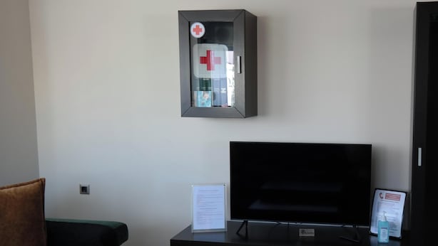 A living room with a flat-screen TV, a sofa, a coffee table, and a small cabinet.
