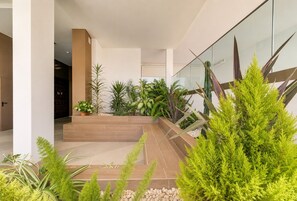 A modern indoor garden with various plants and a glass railing. - Spacious 2-Suite Flat with Balconies | Portimão (Portimão)