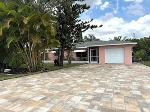 A residential property with a paved driveway, a garage, and a well-maintained lawn. - Bonita Shores Beach House Close to Doc's, Barefoot Beach, Naples +Dog-Friendly! (Bonita Springs)