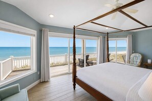 Un lit à baldaquin avec vue sur la plage et l’océan.