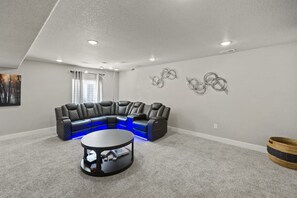 A modern living room with a sectional sofa, a coffee table, and decorative wall art. - Spacious 3-bedroom house with AC in welcoming Colorado Springs (Colorado Springs)