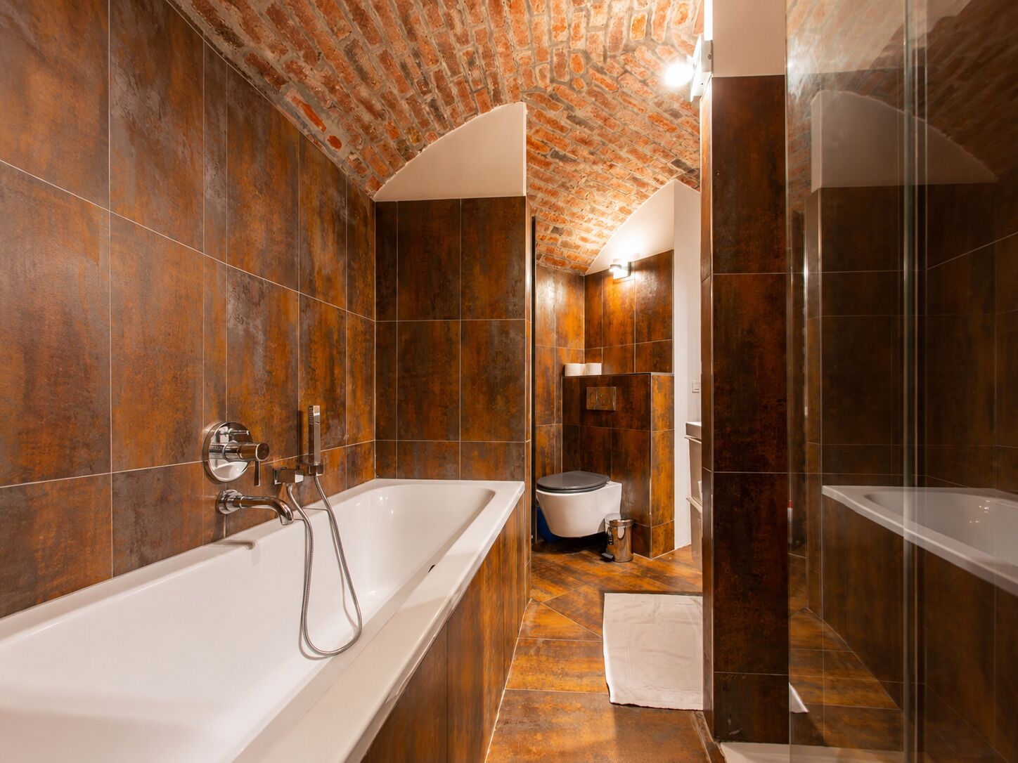 A modern bathroom with a large bathtub, a shower area, and a toilet.