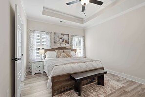 A bedroom with a bed, a bench, a nightstand, and a ceiling fan. - Big Ridge Hideaway - Hot Tub (Talking Rock)