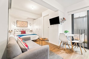 A modern hotel room with a bed, a sofa, a desk, and a TV. - Loft in the Historic Center of the City (Ciudad de México)