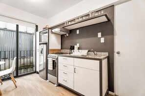 A compact kitchen with a stove, oven, and modern appliances. - Loft in the Historic Center of the City (Ciudad de México)