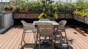 An outdoor patio with a table and chairs, surrounded by greenery and a clear sky. - Loft in the Historic Center of the City (Ciudad de México)