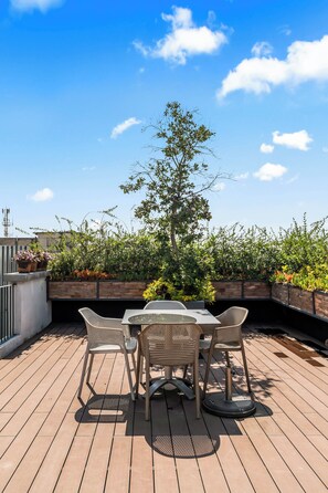 An outdoor patio with a table and chairs, surrounded by greenery and a clear sky. - Loft in the Historic Center of the City (Ciudad de México)