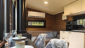 A cozy cabin interior with a dining area, a sofa, and a kitchen.