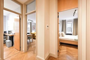 Ein modernes Hotelzimmer mit einem Bett, einem Schreibtisch und einer Küchenzeile.