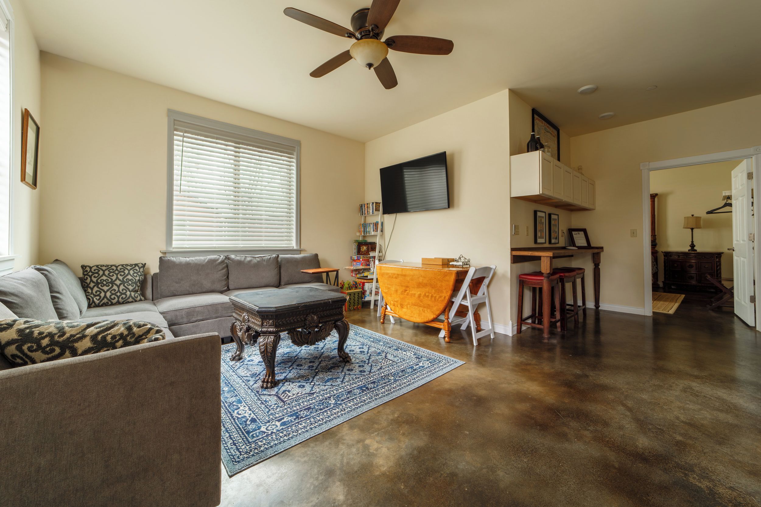 A living room with a sofa, coffee table, and a patterned rug.