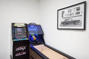 A pinball machine labeled 'Galaxia' and a framed photograph of a car on a wall. - Treasure Coast Villa 5bd + pool hot tub game room (Port St. Lucie)
