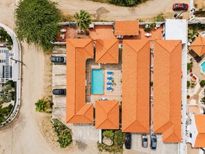 Ein Luftbild zeigt ein Resort mit mehreren Gebäuden, einem Schwimmbad und einem Parkplatz.