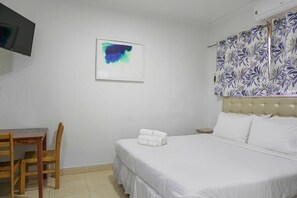 Ein Hotelzimmer mit Bett, Schreibtisch und Stuhl.