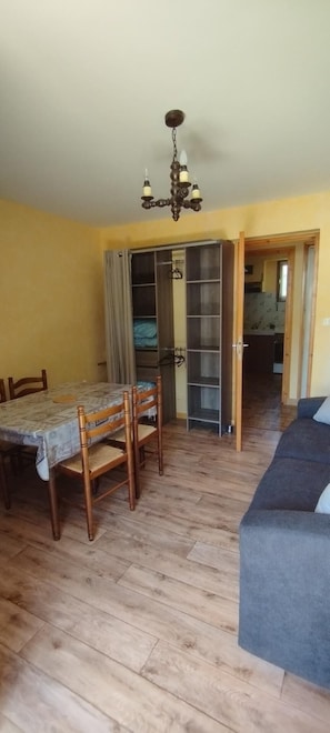 A room with a dining table, chairs, a sofa, and a bookshelf. - 150m from ski slopes, 1st floor, balcony, parking, 36m², Valloire (Valloire)