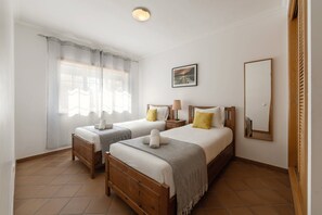 A hotel room with two beds, a large mirror, and a painting on the wall. - Destino Praia D'El Rei - Shared Pool (Óbidos)