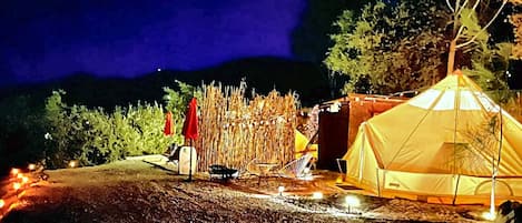 Un campamento con una tienda de campaña, una silla y una mesa pequeña.
