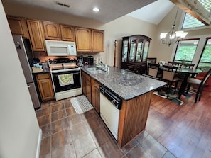A kitchen with wooden cabinets, a microwave, a stove, and a dishwasher.
