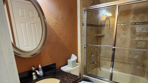 A bathroom with a sink, toilet, and glass-enclosed shower.