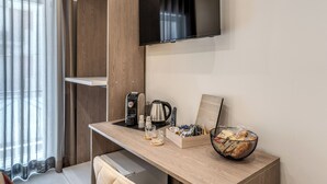 Eine moderne Küchenzeile mit Kaffeemaschine, Wasserkocher, einer Schale mit Snacks und einer Fernbedienung.