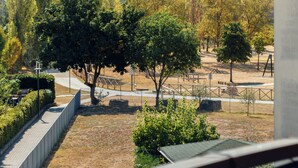 Un parc amb camins, arbres i una zona tancada per una tanca.