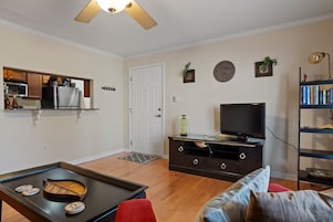 Una sala de estar con televisor, mesa de centro, sofá y estantería.