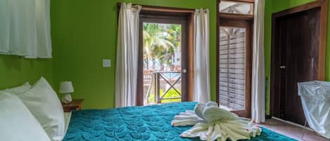 Une chambre d’hôtel avec un lit, une table de chevet, une lampe et une vue sur la piscine par la fenêtre.
