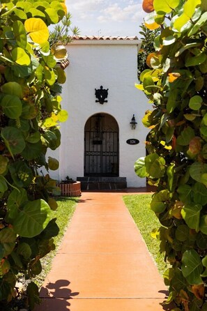 A pathway leading to a white building with a black door and a number plaque. - Private Mansion - Pool - Mins to Beach (Hollywood)