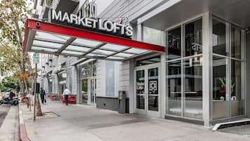 En byggnad med en butiksfasad där det står ”MARKET LOFTS” och en ingång med ett överhäng.