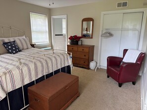A bedroom with a bed, dresser, chair, and a closet. - Private apartment in quiet Athens neighborhood. Walk to UGA sports and campus. (Athens)