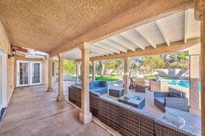 A covered patio area with wicker furniture, a pool, and a view of the backyard. - Serenity Stay in Henderson with Pool! (Henderson)