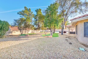 A backyard with a patio, a small lawn, and a house with a tiled roof. - Serenity Stay in Henderson with Pool! (Henderson)