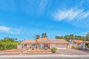A two-story house with a red-tiled roof, a garage, and a landscaped front yard with shrubs and a small tree. - Serenity Stay in Henderson with Pool! (Henderson)