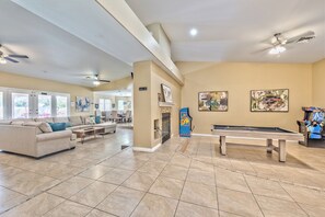 A spacious living room with a pool table, a sofa, and a fireplace. - Serenity Stay in Henderson with Pool! (Henderson)