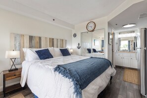 Une chambre moderne avec un grand lit, des lampes de chevet, une horloge et une vue sur la salle de bain attenante.