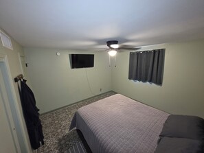 A bedroom with a bed, a ceiling fan, a television, and a window with curtains. - Serene 2-bedroom house with AC in beautiful Tucson close to Catalina adventures (Tucson)